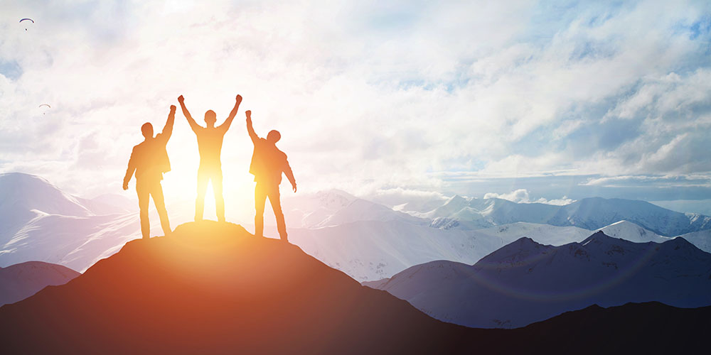 3 persone sulla vetta della montagna esultano. concetto di Leadership