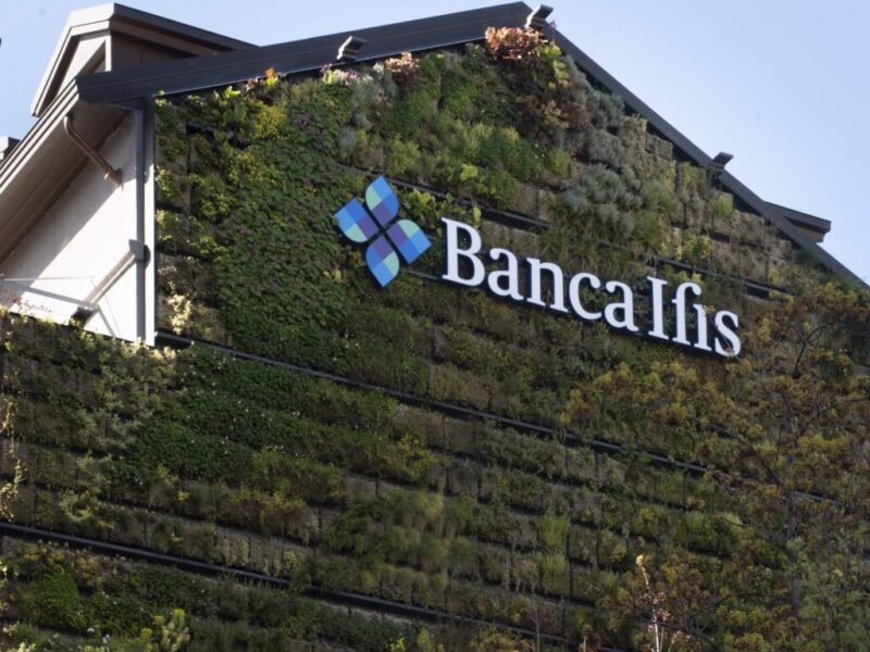 Foto che ritrae esternamente la sede di Banca Ifis in via Borghetto a Milano: facciata ricoperta di vegetazione con logo della banca