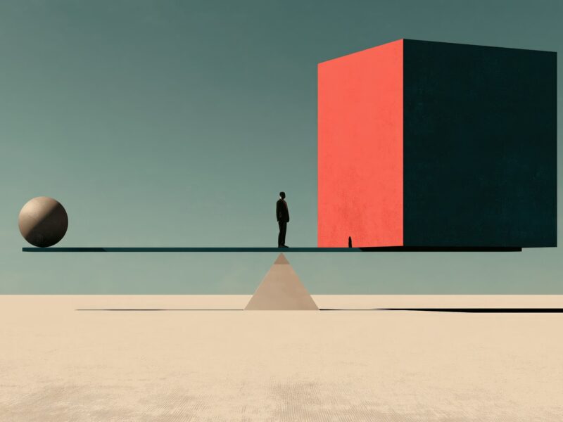 Illustrazione minimal di un'altalena in equilibrio: una figura umana osserva un grande cubo, mentre una piccola sfera dall'altro lato mantiene il bilanciamento, a simboleggiare il dilemma tra misurare e coltivare la competenza.